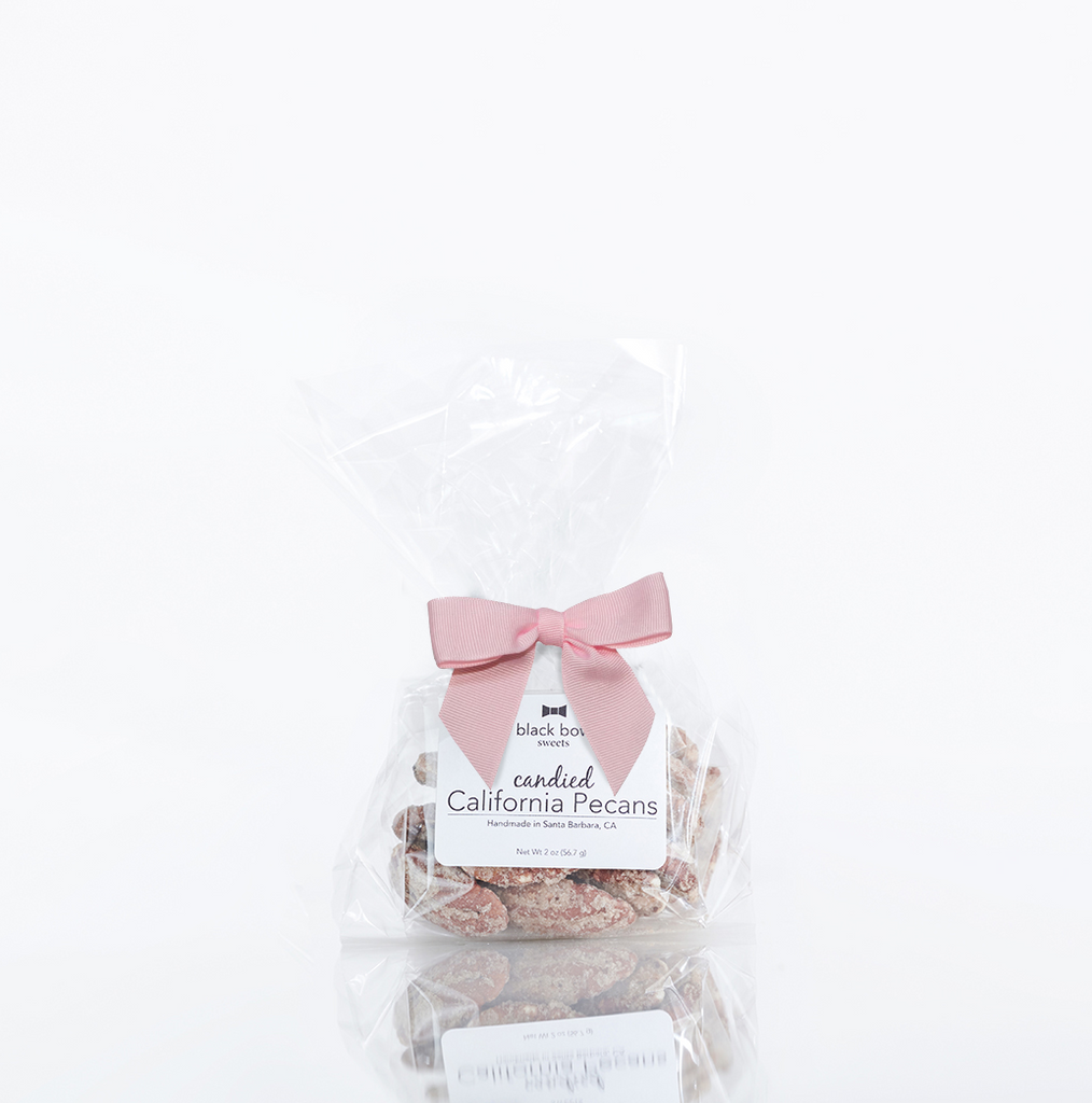 A bag of Black Bow Sweets candied California cinnamon and sugar coated pecans tied with a light pink bow.