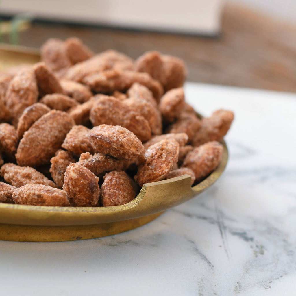 A gold dish filled with Black Bow Sweets' candied California cinnamon and sugar almonds.