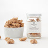 A jar of Black Bow Sweets candied California cinnamon and sugar coated walnuts next to a white bowl filled with the walnuts.