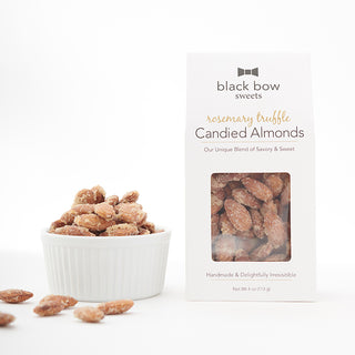 A package of Black Bow Sweets' candied rosemary truffle coated almonds next to a white bowl filled with the almonds.